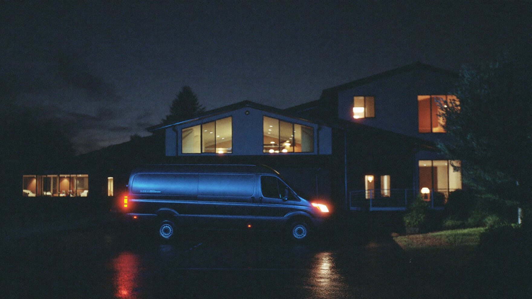 A work van in the driveway of a finished job at night